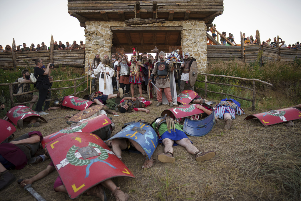 Members of historical reenactment groups wearing Dacian warrior and Roman soldiers outfits, clash in Poiana, Romania, Saturday, July 12, 2025, during the Getodava historical reenactment festival. (AP Photo/Vadim Ghirda)