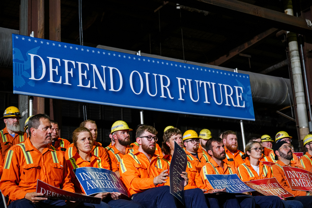 Workers hold signs and sit in stands ahead of Vice President JD Vance's speech at the Cleveland Cliffs Middletown Works, Friday, Aug. 21, 2026, in Middletown, Ohio. (AP Photo/Jon Cherry)