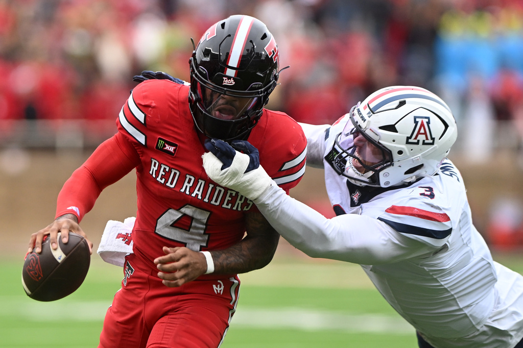 Texas Tech quarterback Tommy Castellanos (4) runs with the ball as Arizona defensive lineman Tre Smith (3) attempts to tackle during the first half of an NCAA college football game, Saturday, Oct. 31, 2026, in Lubbock, Texas. (AP Photo/Annie Rice)