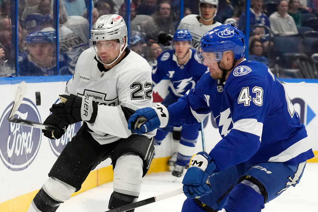 Los Angeles Kings left wing Kevin Fiala (22) flips the puck away from Tampa Bay Lightning defenseman Darren Raddysh (43) during the first period of an NHL hockey game Thursday, Dec. 18, 2025, in Tampa, Fla. (AP Photo/Chris O'Meara)