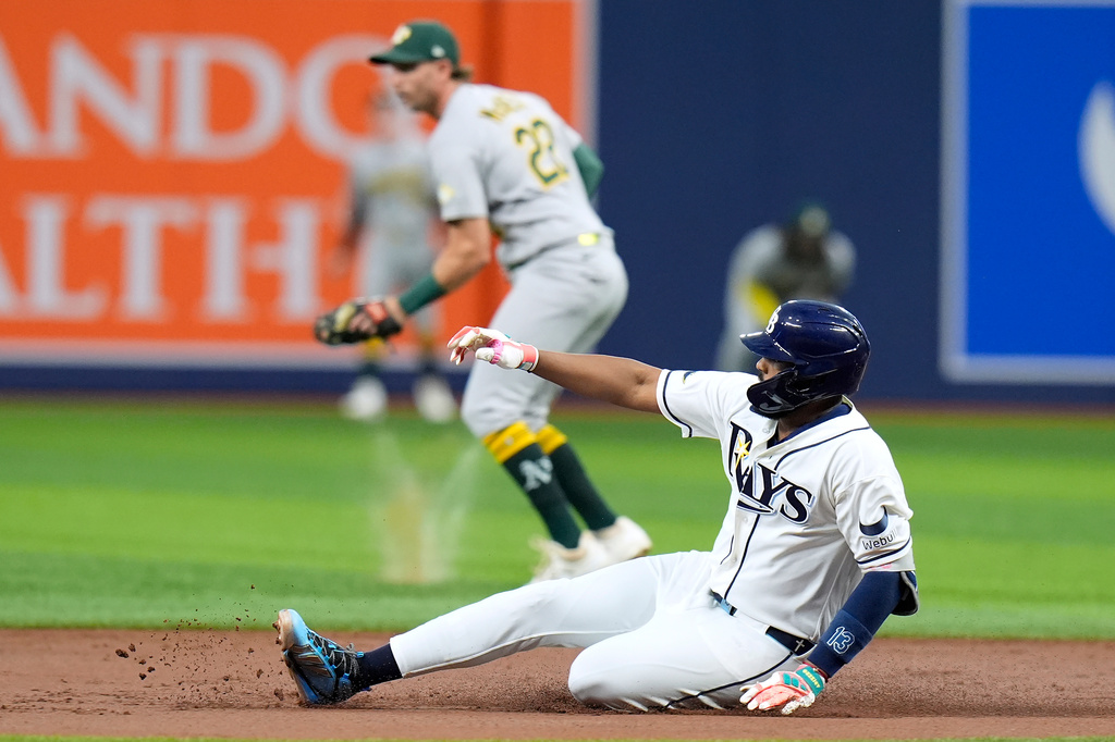 Tampa Bay Rays' Junior Caminero slides into second base with a double in front of Athletics second baseman Jeff McNeil (22) during the first inning of a baseball game Wednesday, Sept. 16, 2026, in St. Petersburg, Fla. (AP Photo/Chris O'Meara)