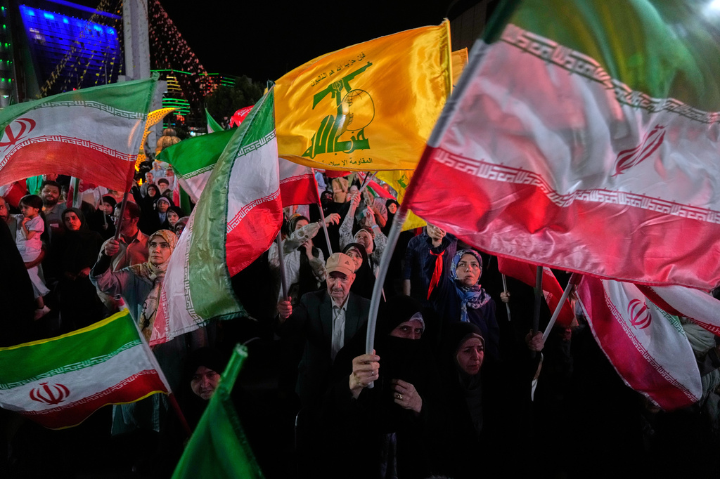 Pro-government Iranian demonstrators wave their country's flags and Lebanon's militant Hezbollah group flags in a gathering in Tehran, Iran, Sunday, June 7, 2026. (AP Photo/Vahid Salemi)