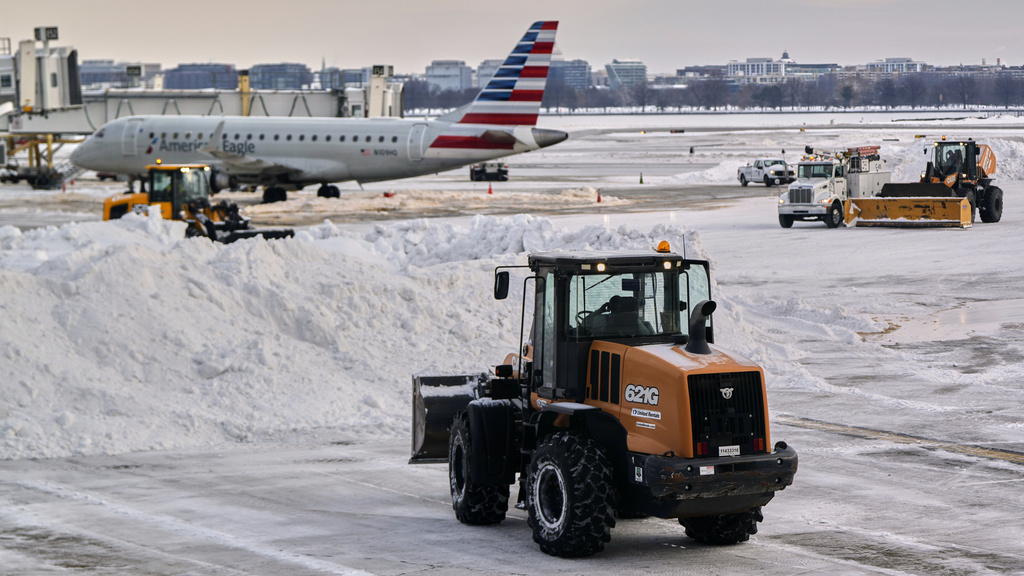 Snow and ice is cleared at Ronald Reagan Washington National Airport, Monday morning, Jan. 26, 2026, in Arlington, Va. (AP Photo/Julia Demaree Nikhinson)
