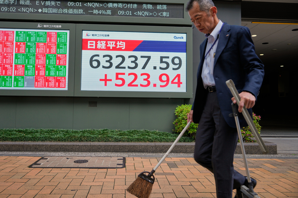 A man sweeps in front of an electronic stock board showing Japan's Nikkei index at a securities firm Monday, May 11, 2026, in Tokyo. (AP Photo/Eugene Hoshiko)