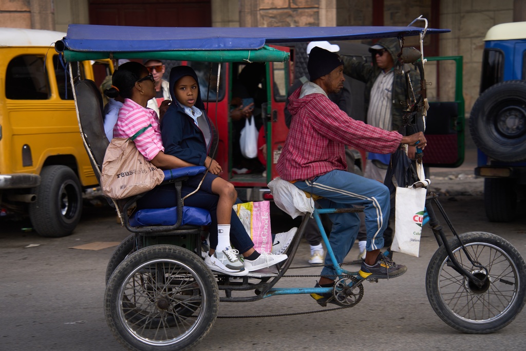 People use a bicycle taxi in Havana, Cuba, Friday, Feb. 6, 2026. (AP Photo/Ramon Espinosa)
