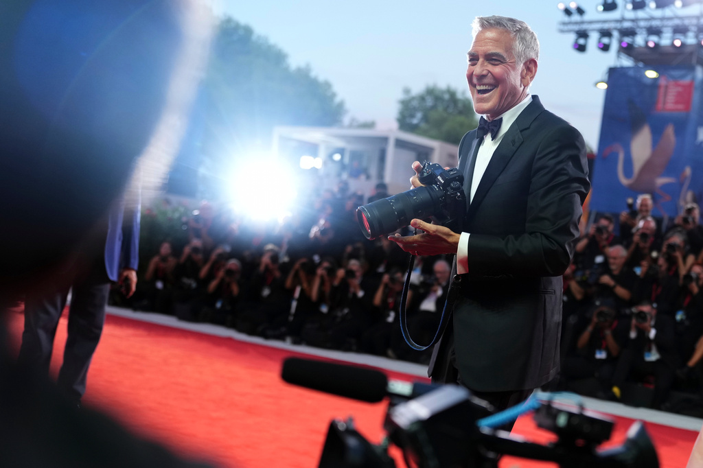 George Clooney uses a photographer's camera after receiving the golden lion for lifetime achievement during the 83rd edition of the Venice Film Festival in Venice, Italy, on Wednesday, Sept. 2, 2026. (Photo by Scott A Garfitt/Invision/AP)