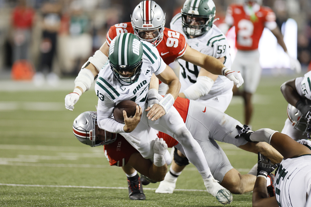 Ohio State defensive lineman Caden Curry (92) and defensive lineman Beau Atkinson, bottom, sack Ohio quarterback Parker Navarro (13) during the second half of an NCAA college football game, Saturday, Sept. 13, 2025, in Columbus, Ohio. (AP Photo/Jay LaPrete)