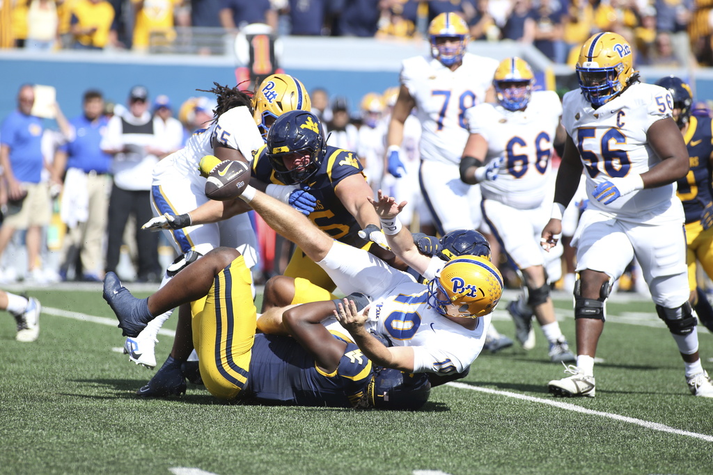 Pittsburgh quarterback Eli Holstein (10) fumbles during the first half of an NCAA college football game against West Virginia Saturday, Sept. 13, 2025, in Morgantown, W.Va. (AP Photo/Kathleen Batten)