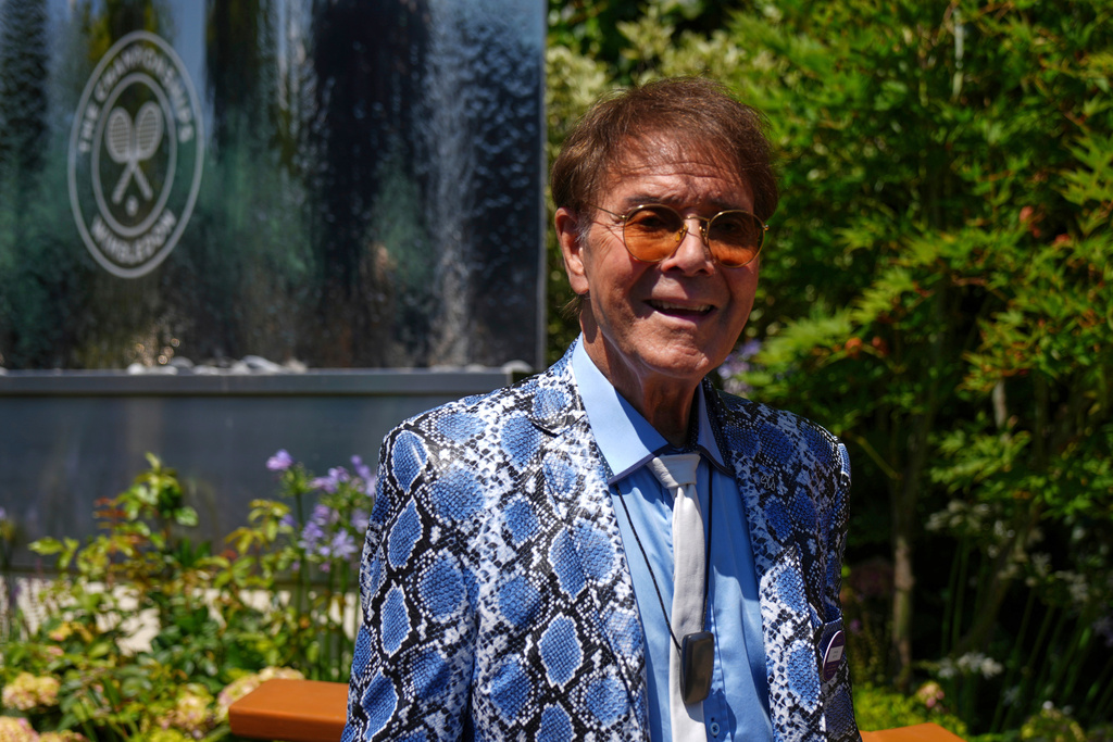 FILE - Singer Cliff Richard poses for a photo as he arrives for day eleven at the Wimbledon Tennis Championships in London, July 10, 2025. (AP Photo/Joanna Chan, File)