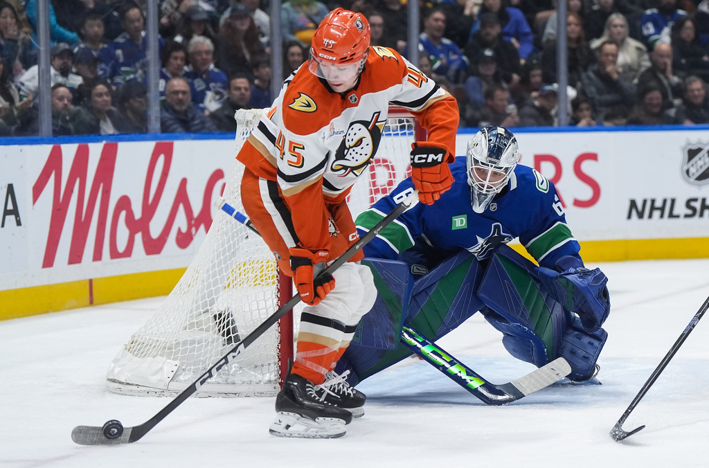 Vancouver Canucks goalie Nikita Tolopilo (60) watches as Anaheim Ducks' Beckett Sennecke (45) controls the puck in front of him during the second period of an NHL hockey game, in Vancouver, on Thursday, Jan. 29, 2026. (Darryl Dyck/The Canadian Press via AP)