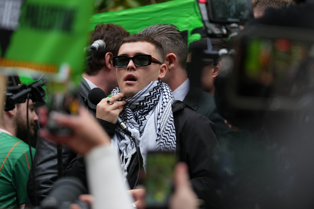 Liam Óg Ó hAnnaidh, aka Mo Chara, a member of the Irish language band Kneecap, celebrates after he left Woolwich Crown Court in London, Friday, Sept. 26, 2025, after Chief Magistrate, Senior District Judge Paul Goldspring, dismissed a terrorism offence relating to displaying a flag in support of Hezbollah during a performance with the band in November 2024, on a technical error. (AP Photo/Joanna Chan)