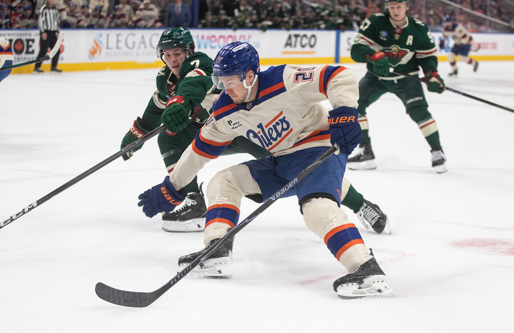 Minnesota Wild's Brock Faber (7) tries to stop Edmonton Oilers' Curtis Lazar (20) during second period NHL action, in Edmonton on Saturday, Jan. 31, 2026. (Jason Franson/The Canadian Press via AP)