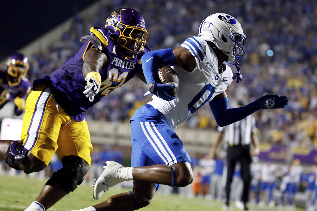 BYU's Evan Johnson (0) runs the ball away from East Carolina offensive lineman Jimarion McCrimon (62) after his interception during the first half of an NCAA college football game in Greenville, N.C., Saturday, Sept. 20, 2025. (AP Photo/Karl DeBlaker)