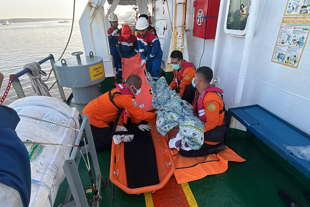 In this photo released by the Indonesia's National Search and Rescue Agency (BASARNAS), rescuers put the body of a victim on a stretcher in Banjarmasin, South Kalimantan, Indonesia Monday, Sept. 14, 2026, after a passenger ferry overturned in bad weather in the Java Sea on Sunday. (BASARNAS via AP)
