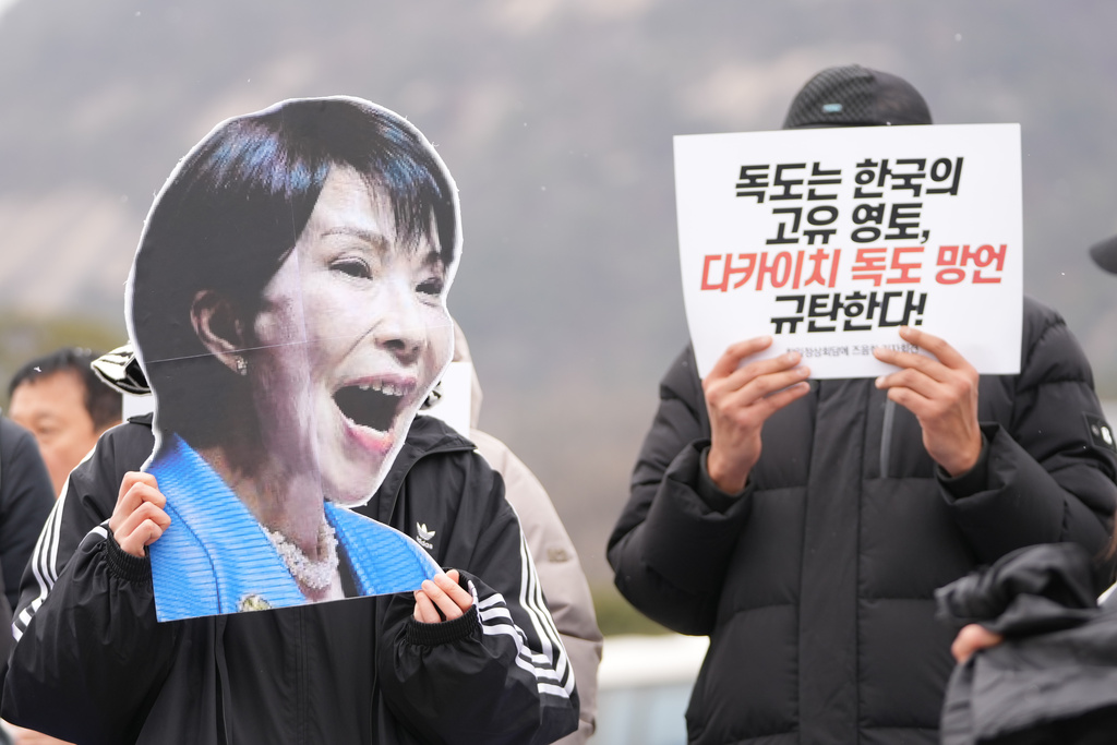 A protester holds a picture of Japan's Prime Minister Sanae Takaichi during a rally ahead of the summit meeting between South Korea and Japan, in Seoul, South Korea, Monday, Jan. 12, 2026. The letters read "Dokdo is South Korea's own territory" and "Denounce, Takaichi's comment on Dokdo." (AP Photo/Lee Jin-man)