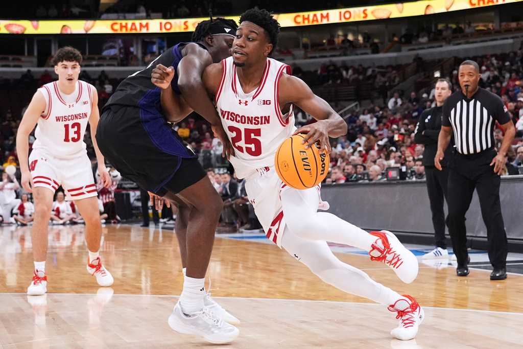 Wisconsin guard John Blackwell, right, drives against Washington guard Wesley Yates III during the first half of an NCAA college basketball game in the third round of the Big 10 Conference tournament Thursday, March 12, 2026, in Chicago. (AP Photo/Nam Y. Huh)