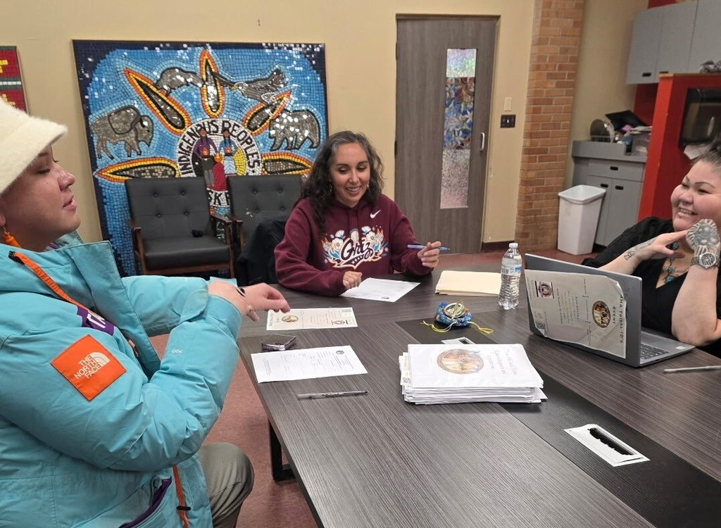 In this photo provided by Phoenix Reeyona Gilmore, from left, Thadd Hall, Amanda Kremer and Christine Yellow Bird attend a pop-up tribal ID event hosted by the Mandan Hidatsa and Arikara Nation at the Minnesota Indian Women’s Resource Center in Minneapolis on Sunday, Jan. 25, 2026. (Phoenix Reeyona Gilmore via AP)
