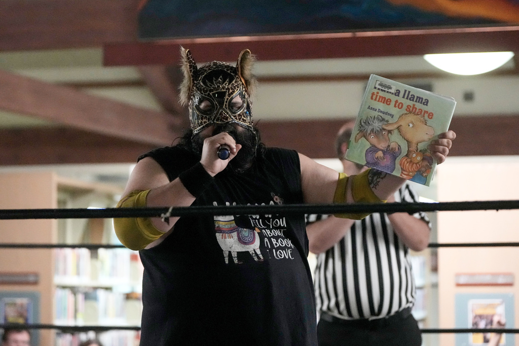 Wrestler Llama Jack reads a Llama Llama book in the ring during a Lucha Libro pro wrestling event at Benicia Public Library Saturday, May 2, 2026, in Benicia, Calif. (AP Photo/Jeff Chiu)