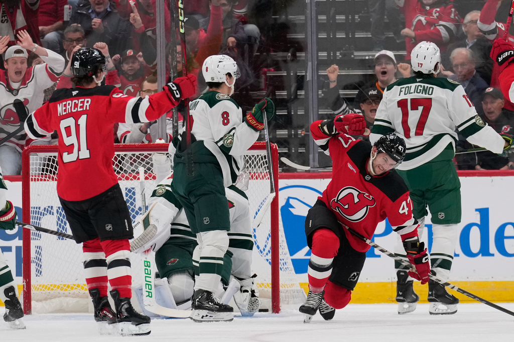 New Jersey Devils' Paul Cotter, second from right, reacts after scoring during the first period of an NHL hockey game against the Minnesota Wild Wednesday, Oct. 22, 2025, in Newark, N.J. (AP Photo/Seth Wenig)