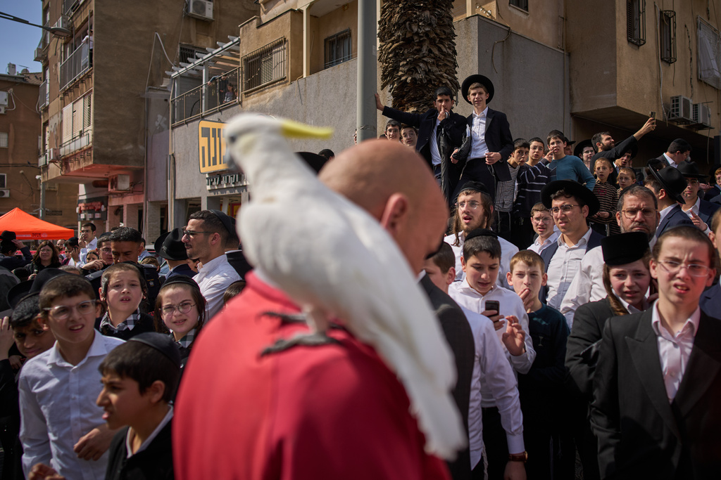People gather outside an apartment building damaged by an Iranian missile strike in Bnei Brak, Israel, Sunday, March 15, 2026. (AP Photo/Oded Balilty)