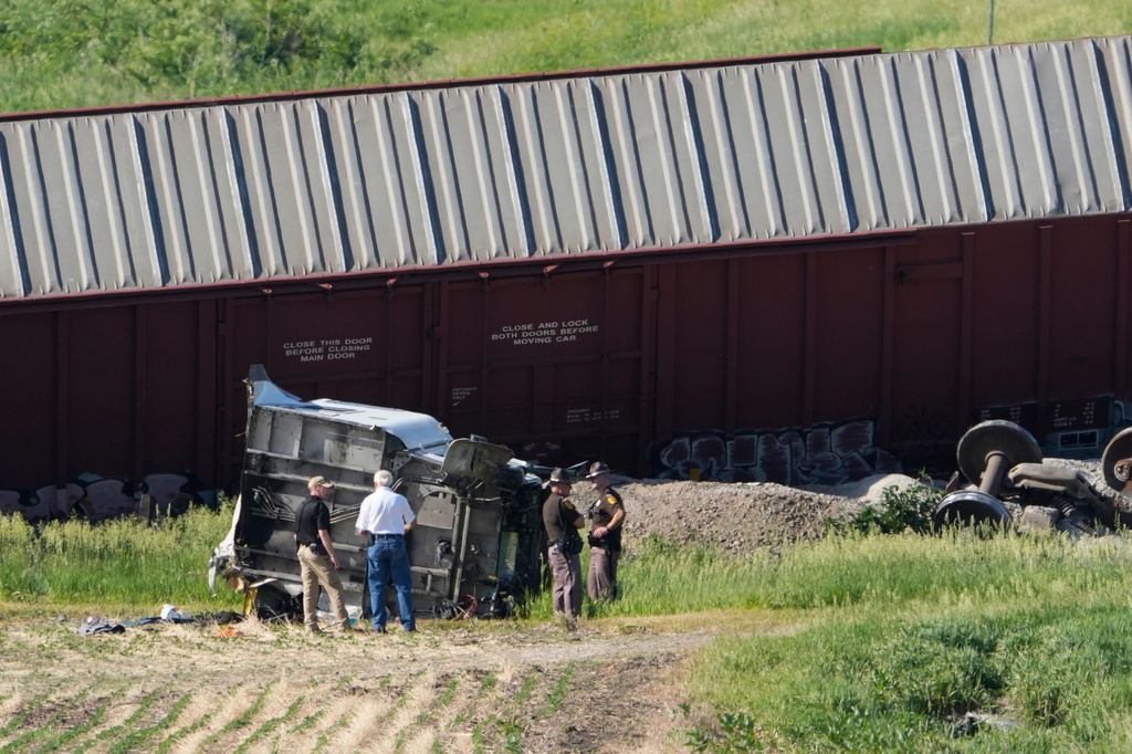 Workers and law enforcement examine debris from a semi-truck after a train derailed on Wednesday, June 3, 2026, near Victor, Iowa. (AP Photo/Charlie Neibergall)
