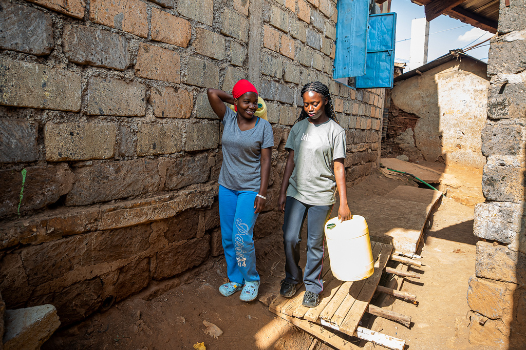 Women walk through the alleys of the Kibera informal settlement to fetch water on the outskirts of Nairobi, Kenya, Feb. 12, 2026. (AP Photo/Atieno Muyuyi)