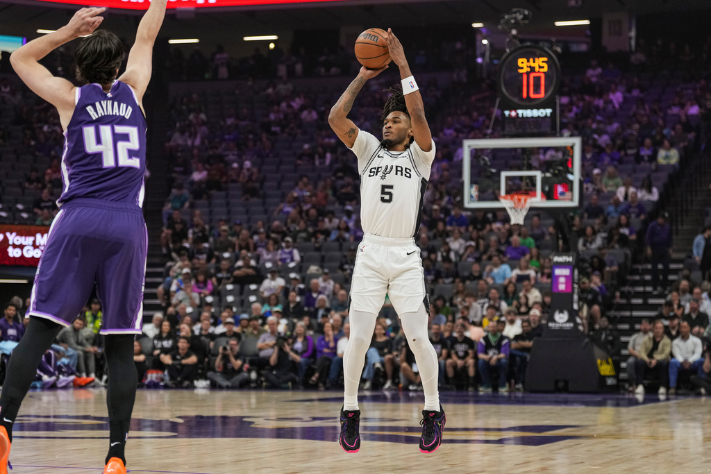 San Antonio Spurs guard Stephon Castle (5) shoots a 3-point basket during the first half of an NBA basketball game against the Sacramento Kings, Tuesday, March 17, 2026, in Sacramento, Calif. (AP Photo/Justine Willard)