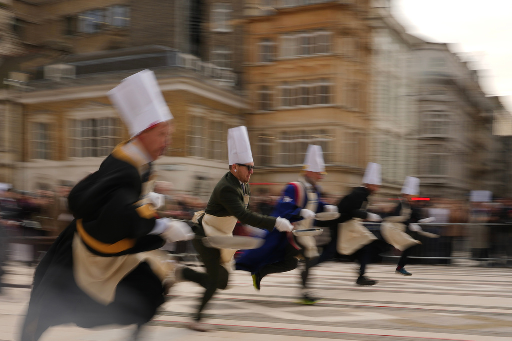 Competitors participate in a traditional pancake race by livery companies at the Guildhall in London, Tuesday, Feb. 17, 2026. (AP Photo/Kin Cheung)