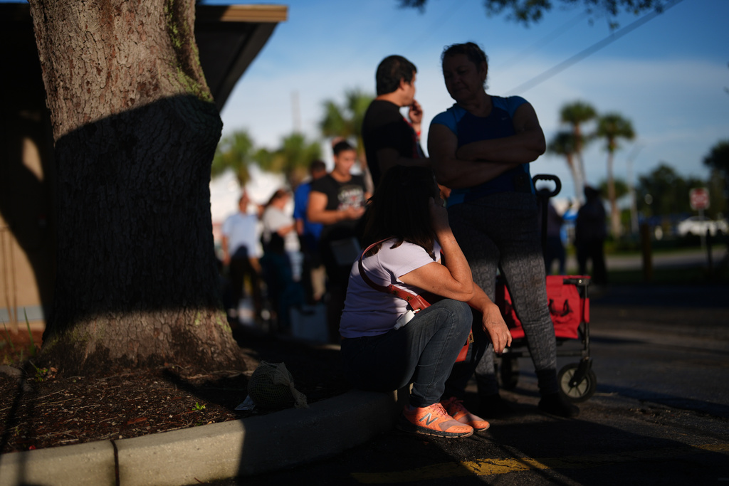 People wait in line at a food pantry that provides assistance to anyone in need, including some migrants who have had their legal protections and work permits terminated, Friday, Aug. 22, 2025, in Orlando, Fla. (AP Photo/Rebecca Blackwell)