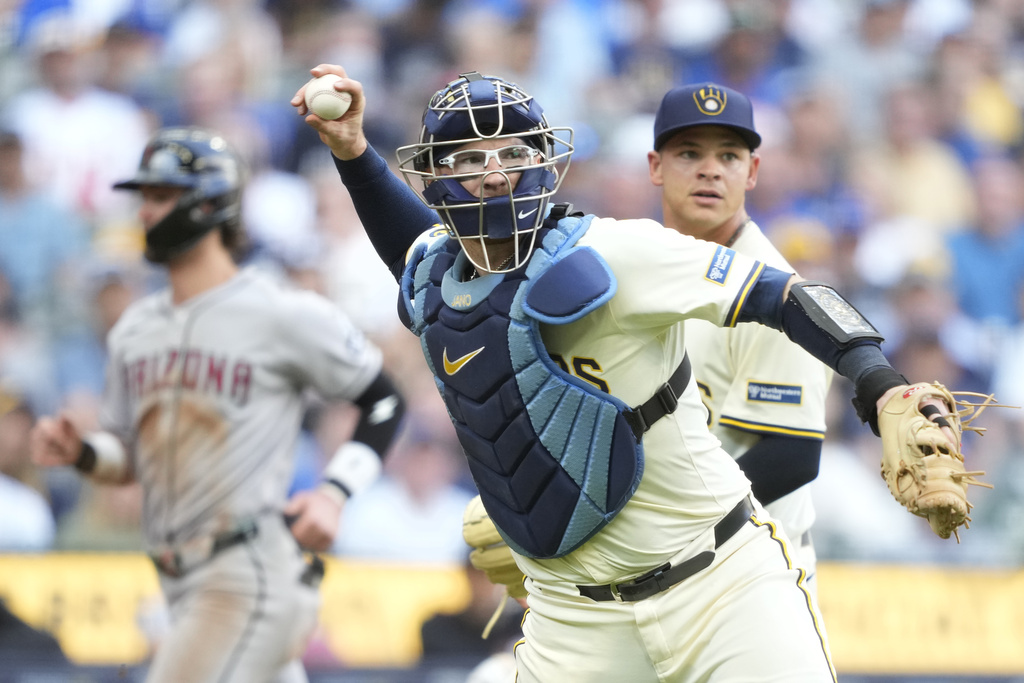 Milwaukee Brewers catcher Danny Jansen (33) throws out Arizona Diamondbacks' Ildemaro Vargas (6) at first during the fifth inning of a baseball game, Thursday, Aug. 28, 2025, in Milwaukee. (AP Photo/Kayla Wolf)