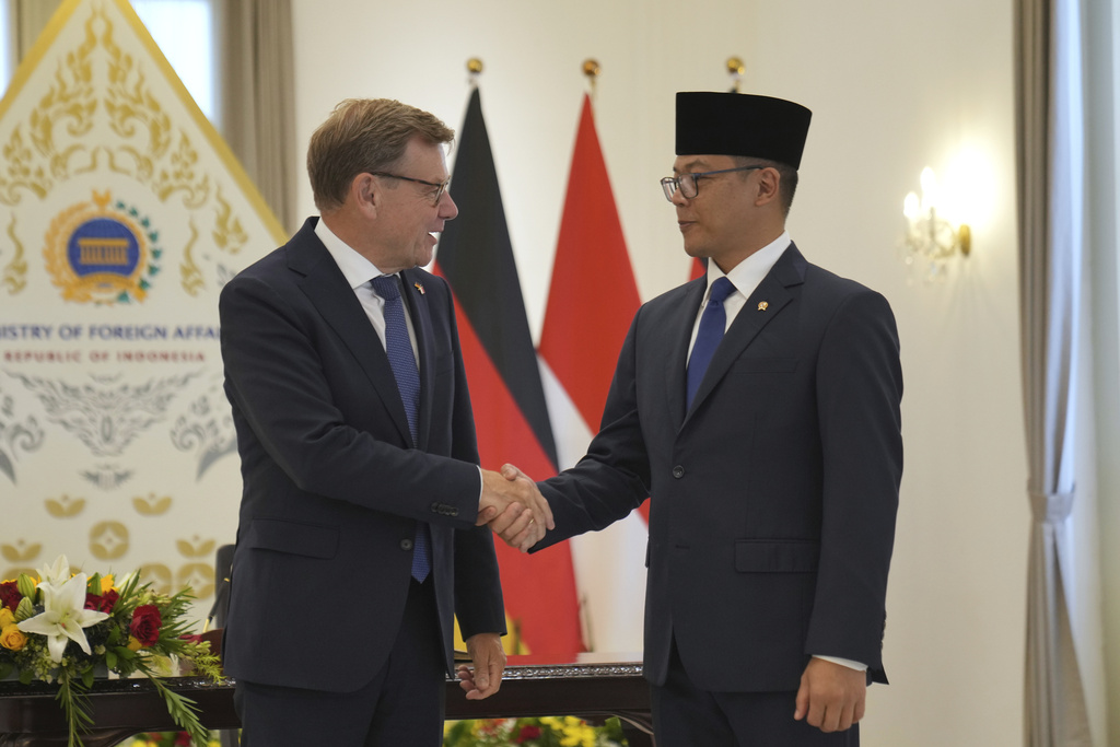 German Foreign Minister Johann Wadephul, left, is greeted by his Indonesian counterpart Sugiono during their meeting in Jakarta, Indonesia, Wednesday, Aug. 20, 2025. (AP Photo/Dita Alangkara)
