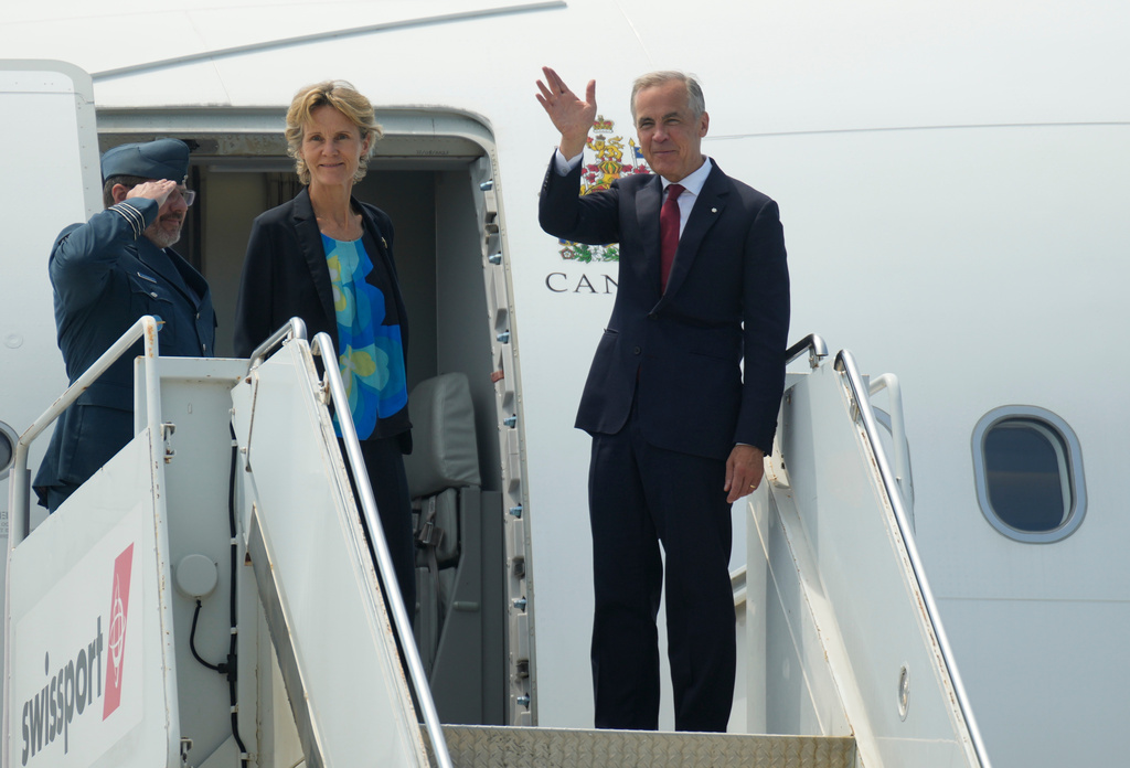 Canada Prime Minister Mark Carney waves as he and Diana Fox Carney board a government plane in Ottawa, Monday, July 6, 2026. (Adrian Wyld/The Canadian Press via AP)