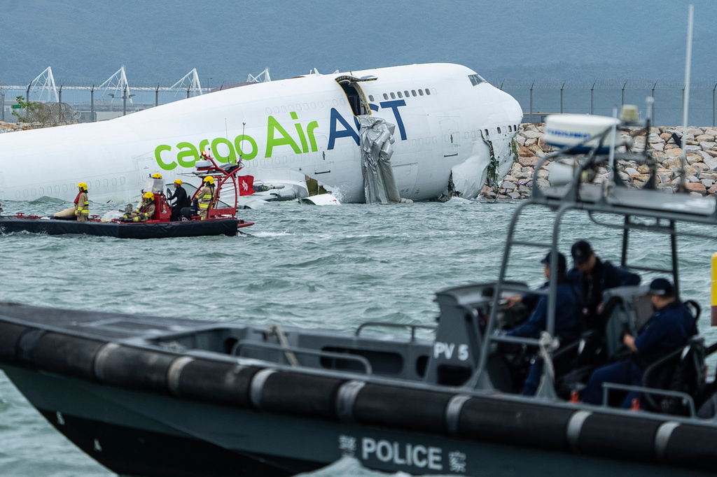 Rescue workers approach a cargo aircraft that skidded off a Hong Kong runway on Monday, Oct. 20, 2025. (AP Photo/Chan Long Hei)