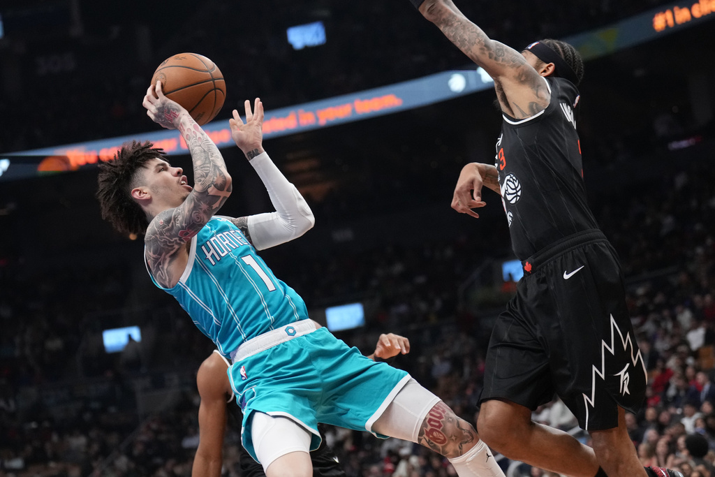 Charlotte Hornets guard Lamelo Ball (1) looks to shoot as Toronto Raptors forward Brandon Ingram (3) defends during first-half NBA basketball game action in Toronto, Monday, Nov. 17, 2025. (Nathan Denette/The Canadian Press via AP)