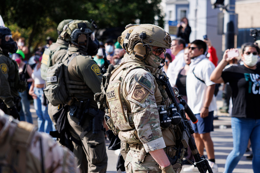 Federal officers stand guard in the Brighton Park neighborhood of Chicago, on Saturday, Oct. 4, 2025, after protesters learned that U.S. Border Patrol shot a woman Saturday morning on Chicago's Southwest Side. (Anthony Vazquez/Chicago Sun-Times via AP)