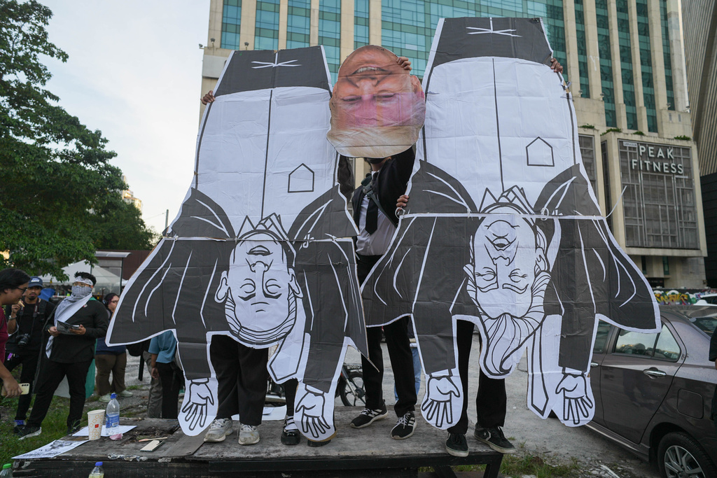 Protesters hold a cut out of President Donald Trump and Israel Prime Minister Benjamin Netanyahu, during a demonstration against U.S. President Donald Trump's attendance at the Association of Southeast Asian Nations (ASEAN) Summit, in Kuala Lumpur, Malaysia, on Sunday, Oct. 26, 2025. (AP Photo/Azneal Ishak)