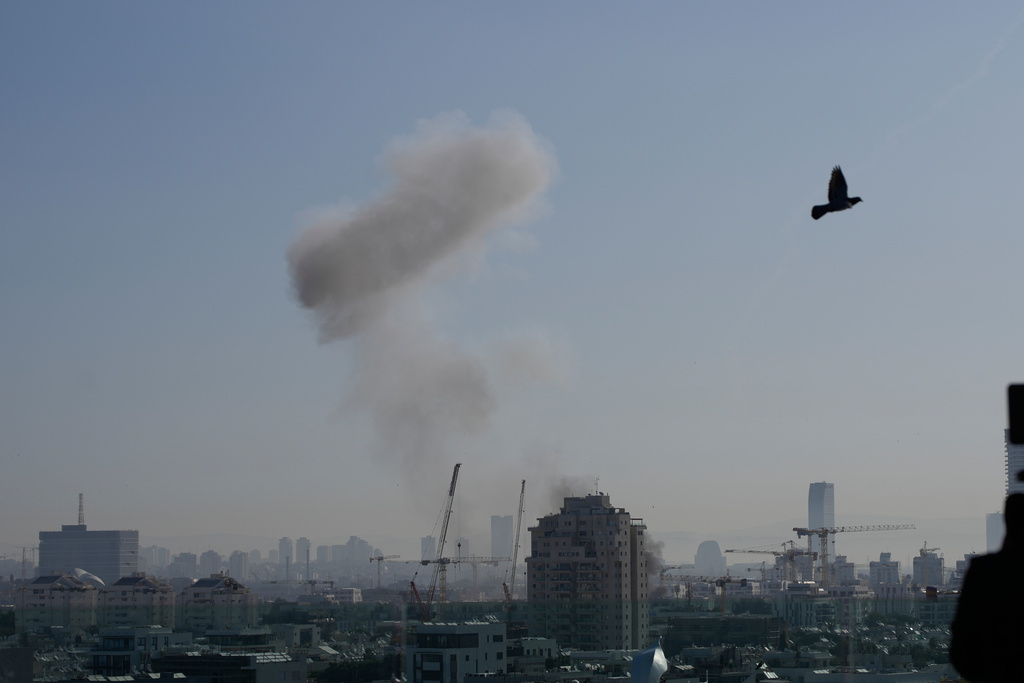 Smoke billows following an Iranian missile strike in Tel Aviv, Israel, Tuesday, March 24, 2026. (AP Photo/Ohad Zwigenberg)