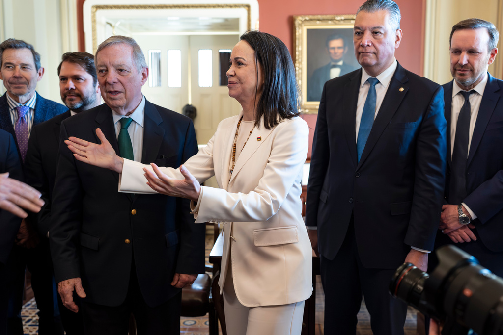 Venezuelan opposition leader Maria Corina Machado is welcomed at the Capitol before a meeting with senators, from left, Sen. John Curtis, R-Utah, Sen. Ruben Gallego, D-Ariz., Sen. Dick Durbin, D-Ill., Sen. Alex Padilla, D-Calif., and Sen. Chris Murphy, D-Conn., as the Nobel Peace Prize recipient visits American leaders two weeks after President Donald Trump toppled Venezuelan president Nicolas Maduro in a stunning military raid, at the Capitol in Washington, Thursday, Jan. 15, 2026. (AP Photo/J. Scott Applewhite)