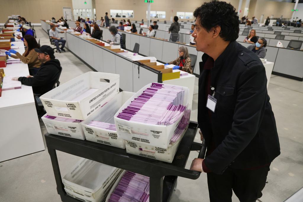 FILE - A worker pushes a cart of received mail ballots at the L.A. County Ballot Processing Center Nov. 4, 2025, in City of Industry, Calif. (AP Photo/Ethan Swope, File)