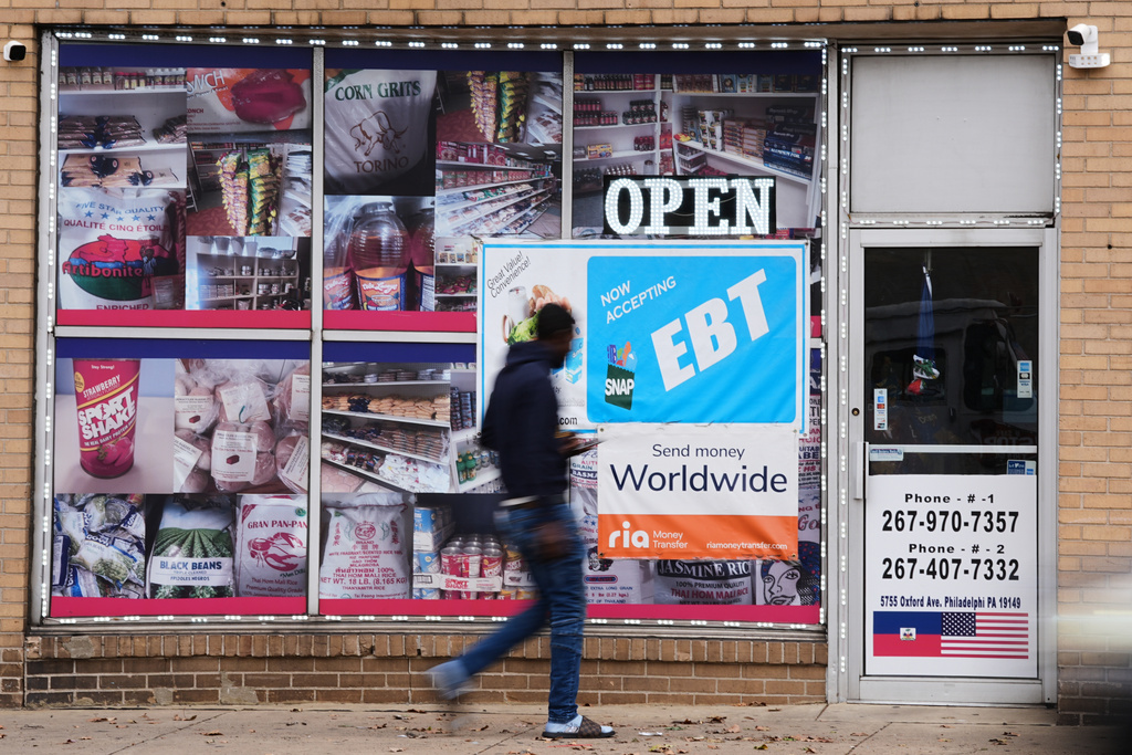 FILE - A customer walks past an EBT payment sign posted on the front window of a grocery store in Philadelphia, Oct. 29, 2025. (AP Photo/Matt Rourke, File)