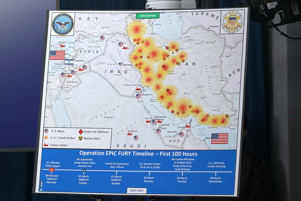 A Dept. of Defense map entitled, Operation EPIC FURY Timeline - First 100 Hours, is displayed during a news conference with Defense Secretary Pete Hegseth and Chairman of the Joint Chiefs of Staff Gen. Dan Caine, at the Pentagon, Wednesday, March 4, 2026, in Washington. (AP Photo/Konstantin Toropin)