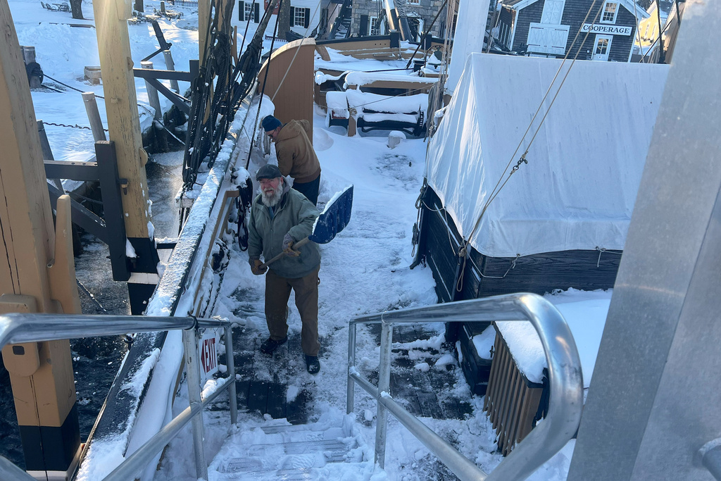Workers carefully shovel away snow from the Charles W. Morgan at the Mystic Seaport Museum in Mystic, Conn., Tuesday, Feb. 24, 2026. (Shannon McKenzie/Mystic Seaport Museum via AP)