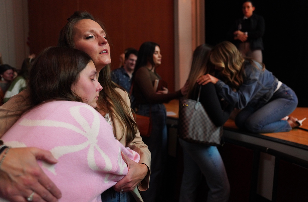 Angela Halili, 29, right, cohost of the Christian podcast, "Girls Gone Bible," prays over a follower during their live show held at the Atlanta Symphony Hall, Friday, Nov. 14, 2025, in Atlanta. (AP Photo/Jessie Wardarski)