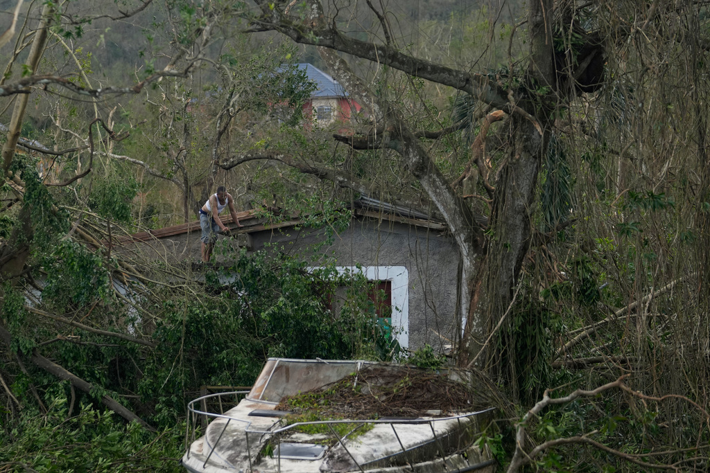 A man checks his home's roof after Hurricane Melissa hit Santa Cruz, Jamaica, Wednesday, Oct. 29, 2025. (AP Photo/Matias Delacroix)