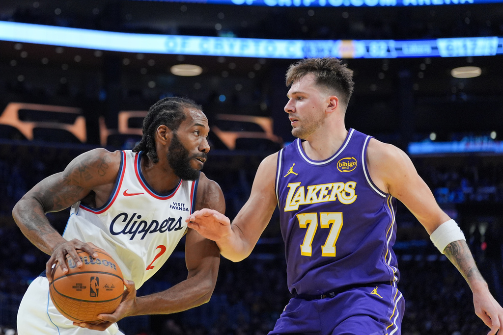 Los Angeles Lakers guard Luka Doncic (77) pressures Los Angeles Clippers forward Kawhi Leonard (2) during the second half of an NBA Cup basketball game Tuesday, Nov. 25, 2025, in Los Angeles. (AP Photo/Jae C. Hong)
