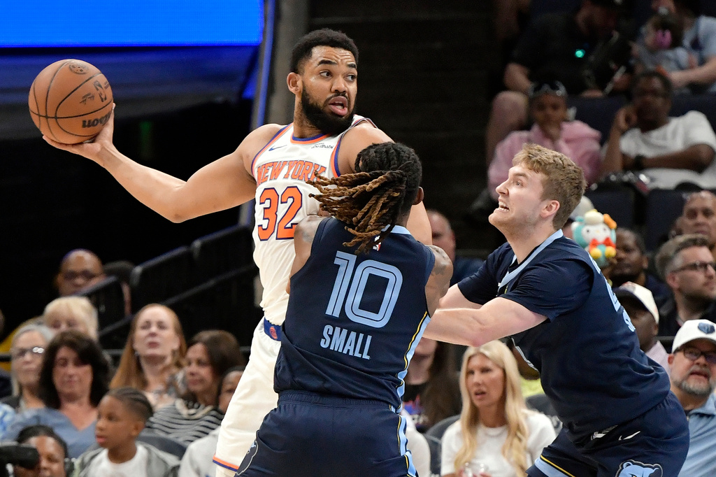 New York Knicks center Karl-Anthony Towns (32) handles the ball against Memphis Grizzlies guards Javon Small (10) and Cam Spencer (24) in the first half of an NBA basketball game Wednesday, April 1, 2026, in Memphis, Tenn. (AP Photo/Brandon Dill)