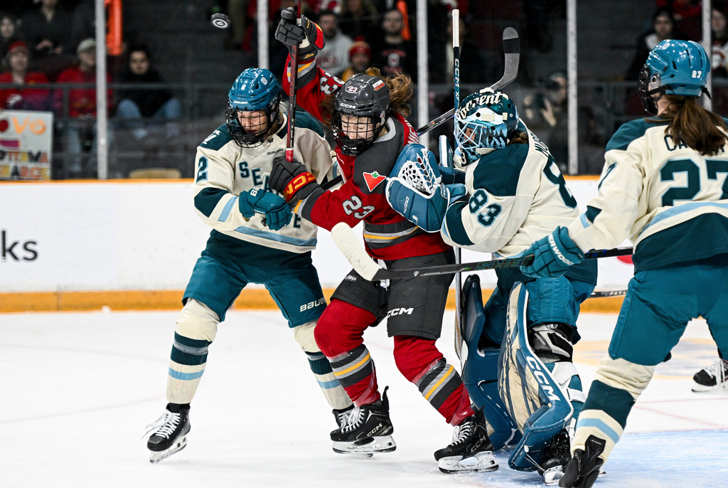 Seattle Torrent goaltender Hannah Murphy (83) looks for the puck as she is screened by Ottawa Charge's Sarah Wozniewicz (23) during the first period of an PWHL hockey game in Ottawa, Ontario, Wednesday, March 4, 2026. (Spencer Colby/The Canadian Press via AP)