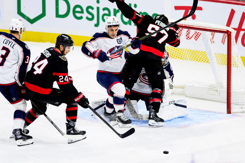 Ottawa Senators' Dylan Cozens (24) battles for possession of the puck against Columbus Blue Jackets' Denton Mateychuk (5) during the third period of an NHL hockey game in Ottawa, Monday, Dec. 29, 2025. (Spencer Colby/The Canadian Press via AP)