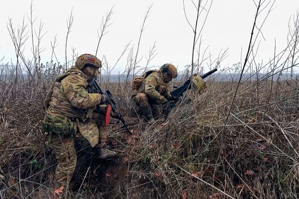 In this image made from video provided by Russian Defense Ministry Press Service on Tuesday, March 31, 2026, Russian soldiers prepare to fire a grenade launcher towards Ukrainian positions on an undisclosed location in Ukraine. (Russian Defense Ministry Press Service via AP)
