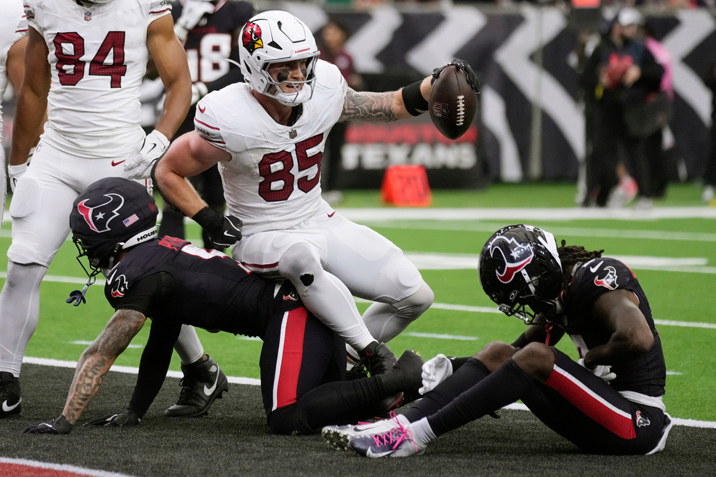 Arizona Cardinals tight end Trey McBride (85) celebrates a touchdown against Houston Texans safeties Jalen Pitre, left, and Calen Bullock, right, during the second half of an NFL football game Sunday, Dec. 14, 2025, in Houston. (AP Photo/Eric Christian Smith)
